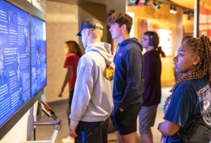 Woman looks at exhibit alongside group of people