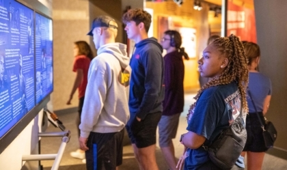 Woman looks at exhibit alongside group of people