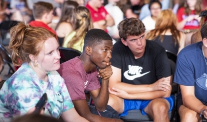 A seated group of young visitors engaged in listening.