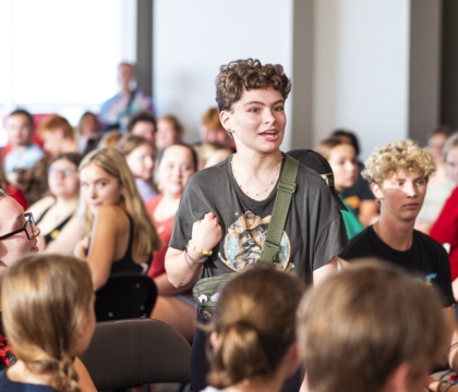 Individual standing up amongst group of young adults