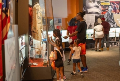 Man and children look at Ali's People Choice robe on display