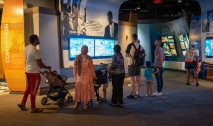 Group of museum visitors in a gallery looking at a display