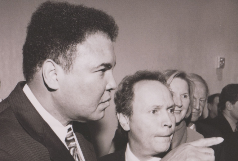 Black and white photo of Muhammad Ali standing next to Billy Crystal and pointing