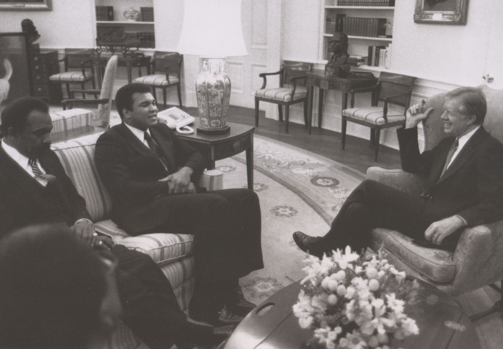 Black and white photo of Muhammad Ali, his father and Jimmy Carter