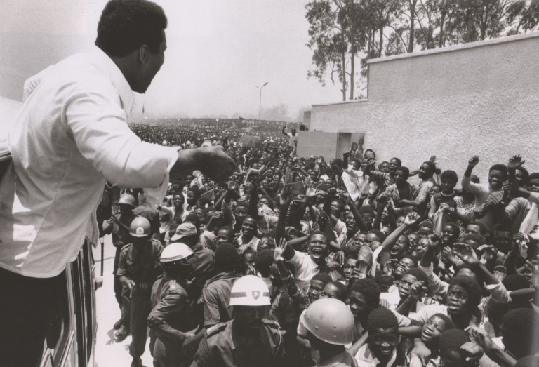 Black and white photo of Muhammad Ali in front of a huge crowd of people in Zaire