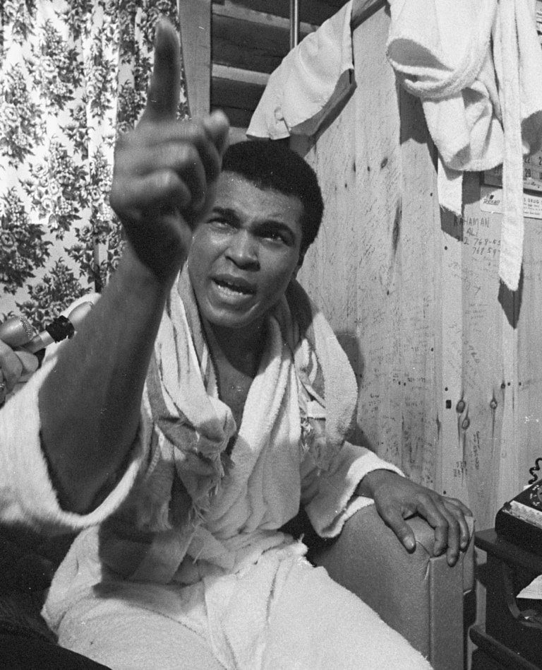 Black and white photo of Muhammad Ali pointing at photographer in Deer Lake training camp