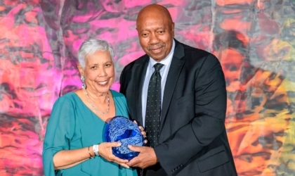 Woman and man holding an award