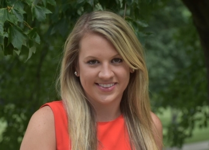 Woman with long blonde hair and a red/orange top