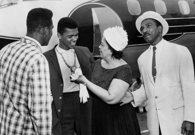 Black and white photo of Muhammad Ali and family as he wears his gold medal