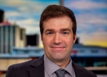 Man with short brown hair in a suit and tie