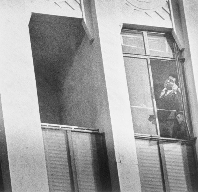 Black and white photo of Muhammad Ali and a man two windows apart