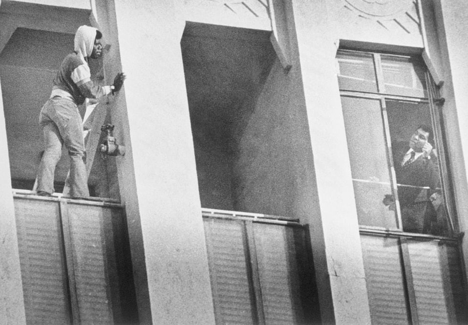 Black and white photo of Muhammad Ali and a man two windows apart