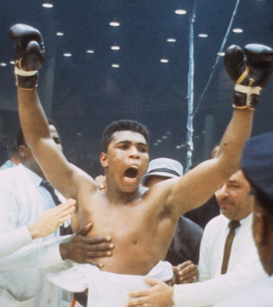 Photo of Muhammad Ali celebrating with gloves in the air