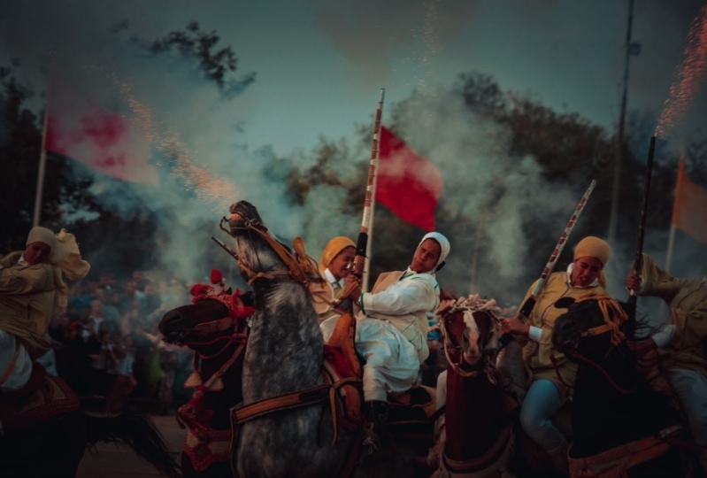 Photo of women on horses as one holds up a red flag