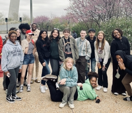 Two Ali Center staff members and a group of teens standing outside