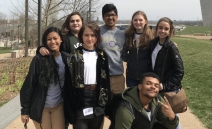 Group of young adults posing in front of St. Louis Arch