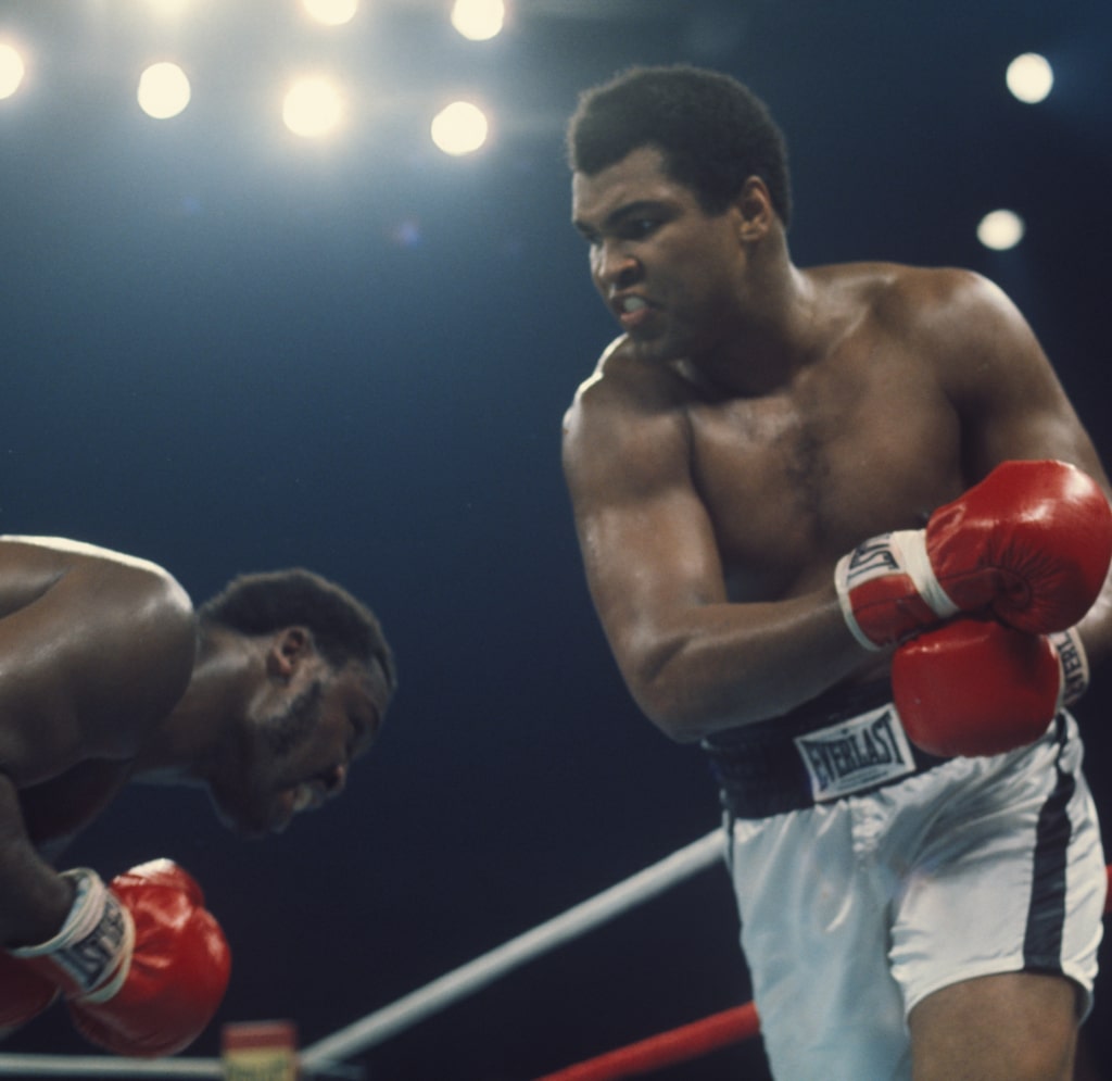 Action photo of Muhammad Ali and Joe Frazier in the ring as Frazier dodges punch