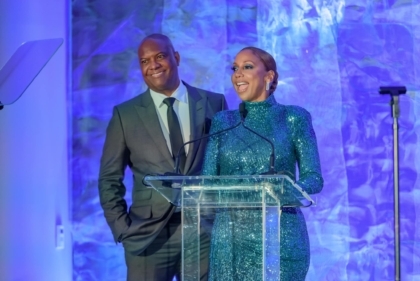 Holly Robinson Peete and Rodney Peete at podium with blue background