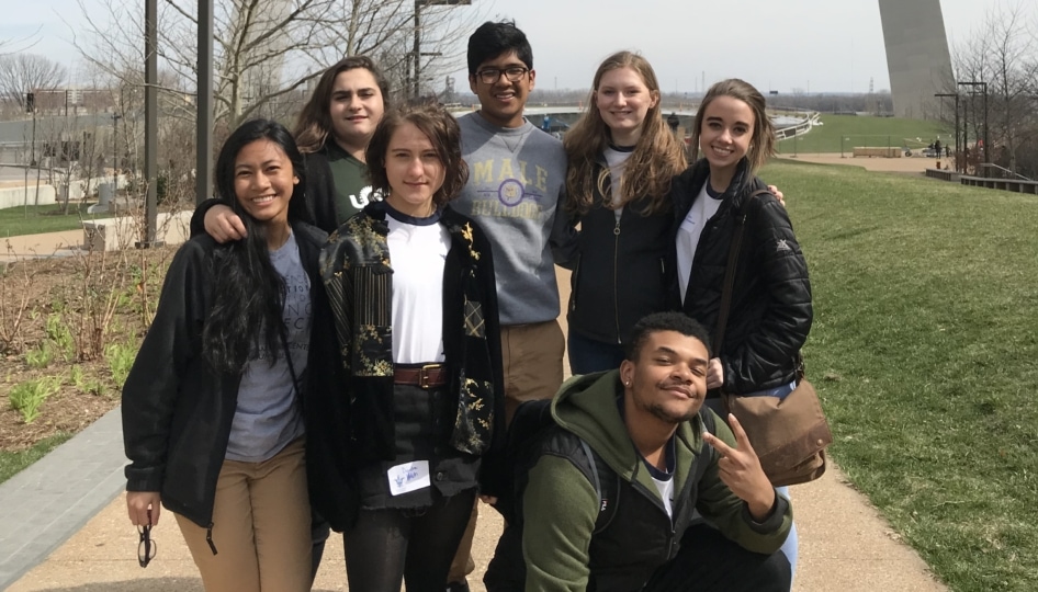 Group of young adults posing in front of St. Louis Arch