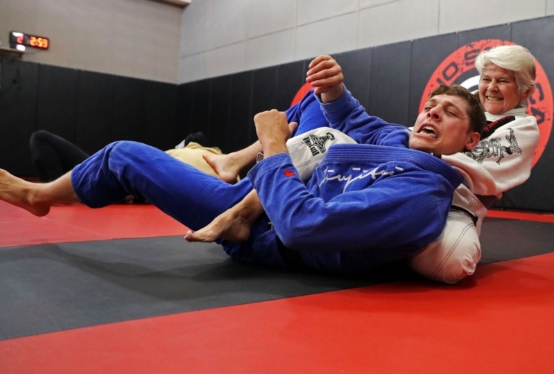 Photo of women in jiujitsu class putting male subject in headlock