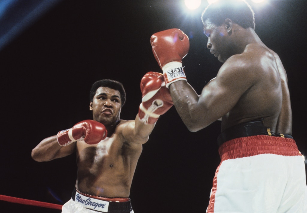 Action photo of Muhammad Ali throwing punch toward Trevor Berbick in the ring