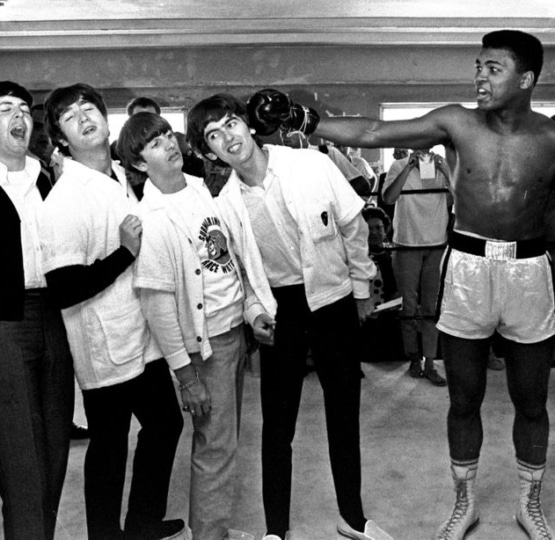 A young Muhammad Ali mock punching the members of the Beatles band